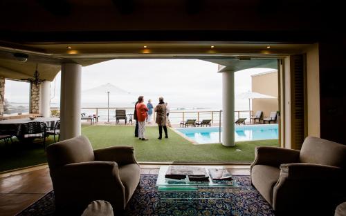 two people standing in a living room with a view of the ocean at Villa Pescatori in Yzerfontein