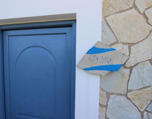 a blue door next to a stone wall at Fairway Villas, A Terra Lusso Property in Gialova