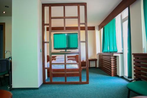 a room with a bunk bed and a television at Hotel Silva in Vatra Dornei