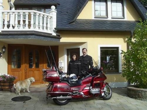 a man and a woman standing next to a red motorcycle at Haus Maria in Olmscheid