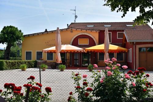 two umbrellas in front of a house with flowers at Agriturismo Paradiso in Sarego
