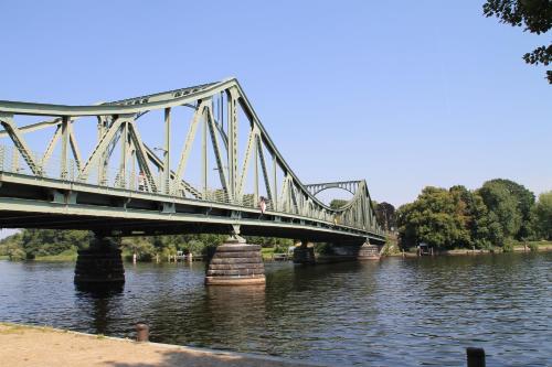 a bridge over a river with people walking on it at Hotel Forsthaus in Berlin
