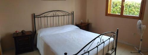 a bedroom with a bed with a metal frame and a window at Casa a Villaggio Paradiso in Santa Cesarea Terme