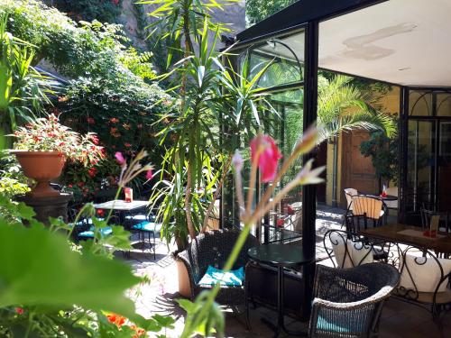 a patio with tables and chairs and plants at Bed and Breakfast "Caffe-caffe" in Kikinda