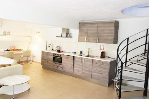 a kitchen with wooden cabinets and a staircase in it at Fairway Villas, A Terra Lusso Property in Gialova