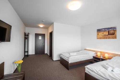 Una cama o camas en una habitación de Hotel Na Farmě Choťovice