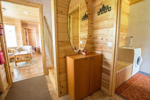 a bathroom in a log cabin with a washing machine at Resort Naaranlahti Cottages in Naaranlahti