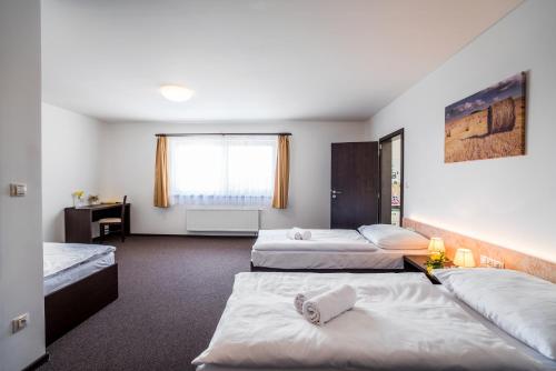 Postel nebo postele na pokoji v ubytování Hotel Na Farmě Choťovice