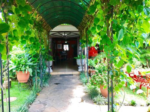 an archway with potted plants in a garden at La Posada del Arcangel in Managua