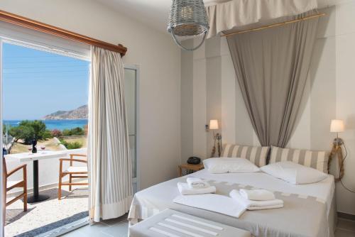 a bedroom with two beds and a view of the ocean at Aeolos Apartments in Kamarai