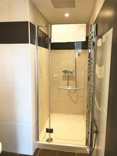 une douche avec une porte vitrée dans une salle de bain dans l'établissement Cannes Festival, à Cannes