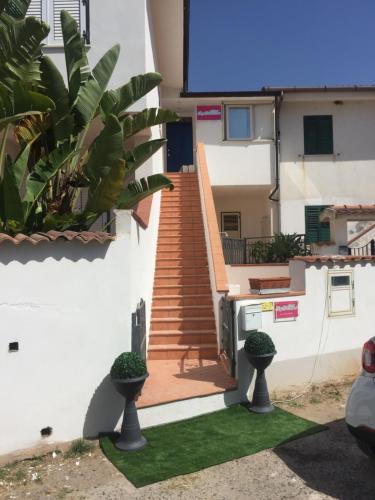 a house with a staircase and two potted plants at Bed & Breakfast Chloe Tropea in Santa Domenica