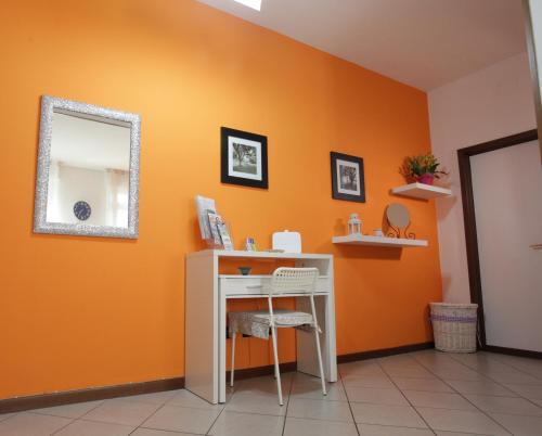 a desk in a room with an orange wall at Casa vacanze Antonia in Bologna