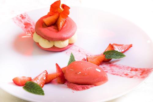 a plate with a dessert with a doughnut and strawberries at Logis Hotel - Restaurant - Spa - Le Relais de Farrou in Villefranche-de-Rouergue