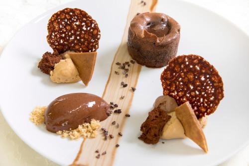 a white plate with different types of desserts on it at Logis Hotel - Restaurant - Spa - Le Relais de Farrou in Villefranche-de-Rouergue