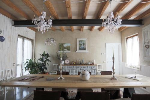 Ca' Blanca في كاستلنوفو ديل جاردا: غرفة طعام مع طاولة خشبية كبيرة وثريات