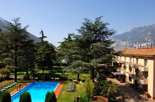 un hotel con piscina y montañas de fondo en Hotel Elisabetta, en Nago-Torbole