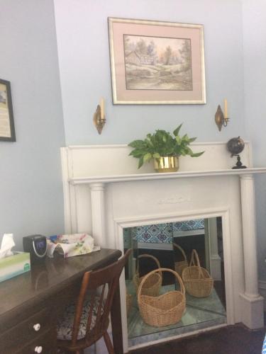 a living room with a fireplace with a table and a picture at Greenwood Bed & Breakfast in Greensboro