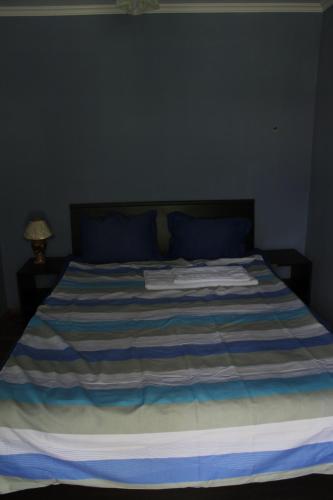 a blue and white bed with towels on it at The Kiwi House in Lagodekhi