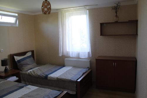 a bedroom with two beds and a window at The Kiwi House in Lagodekhi