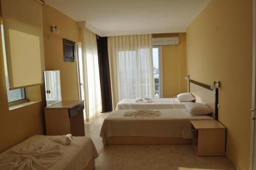a hotel room with two beds and a window at Blue Sea Hotel & Spa in Kuşadası