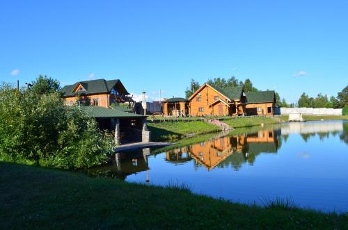 een huis naast een rivier met huizen op de achtergrond bij Gostynna sadyba Kit Bayun in Teterivka