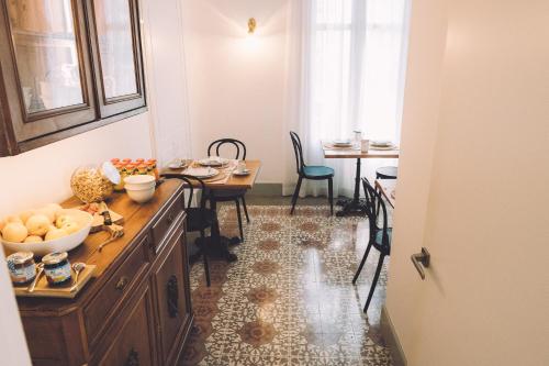 Una cocina con una alacena de madera y una mesa y sillas. en Hotelet Casa Padró, en Manresa
