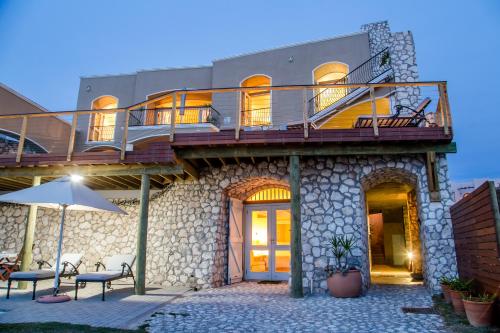 a large building with a deck and a patio at Villa Pescatori in Yzerfontein