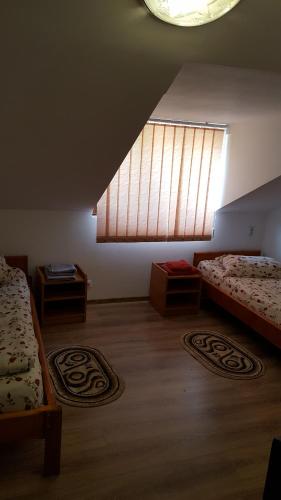 a large room with two beds and a window at Casa Borcean in Sasca Montană