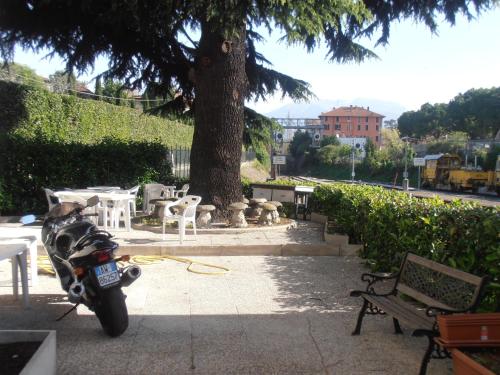 a motorcycle parked on a sidewalk next to a tree at Locanda Diana in Iseo