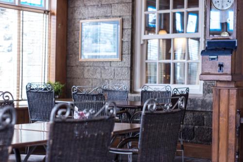 an empty restaurant with tables and chairs and windows at Yorkshire Bridge Inn in Bamford