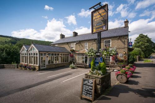 un pub avec un panneau devant un bâtiment dans l'établissement Yorkshire Bridge Inn, à Bamford