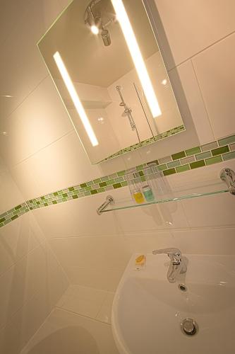 a white bathroom with a sink and a mirror at Yorkshire Bridge Inn in Bamford