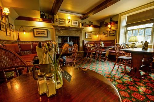 a restaurant with a table and chairs and a fireplace at Yorkshire Bridge Inn in Bamford