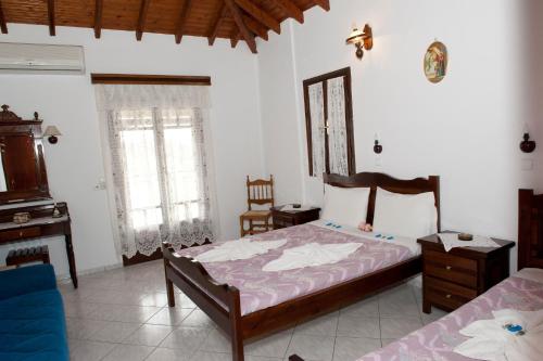 ein Schlafzimmer mit einem Bett, einer Kommode und zwei Fenstern in der Unterkunft Katerina Apartments in Marathokampos