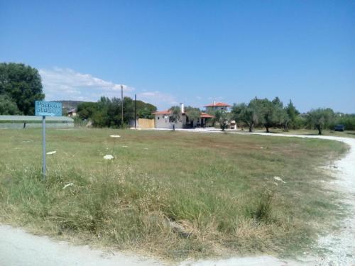 a sign in a field next to a road at Pappou's Studios in Ormos Panagias