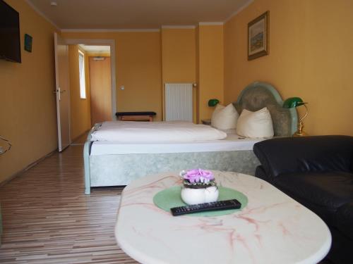 um quarto de hotel com duas camas e uma mesa com controlo remoto em Hotel Restaurant LR6 em Bad Sooden-Allendorf