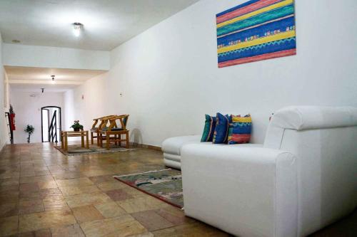 a living room with a white couch and a table at Hotel Zibamba in São Francisco do Sul