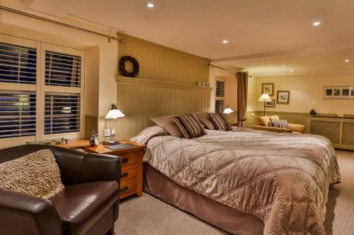 a bedroom with a bed and a chair at The Coach House Brecon in Brecon