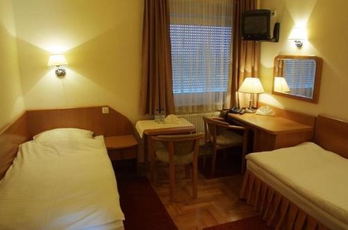 a hotel room with a bed and a desk at Hotel Bielany in Bielany Wrocławskie