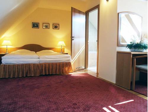 a bedroom with a bed and a large red rug at Hotel Bielany in Bielany Wrocławskie
