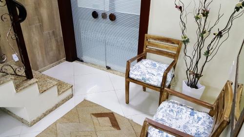 a room with two chairs and a staircase and a door at Hotel Orleans in Petrópolis