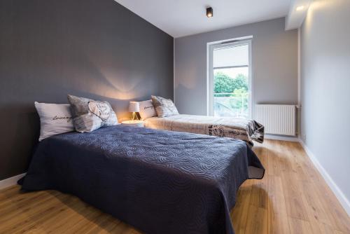 a bedroom with two beds and a window at Apartament Marina Przy Porcie Nad Niegocinem in Giżycko