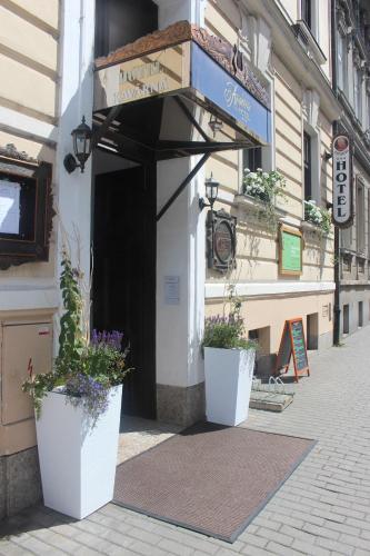 a building with two potted plants in front of it at Hotel Amadeus in České Budějovice