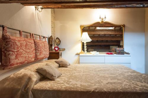 a bedroom with a bed and a mirror on the wall at Borgo dei Salinari Apartments in Cervia