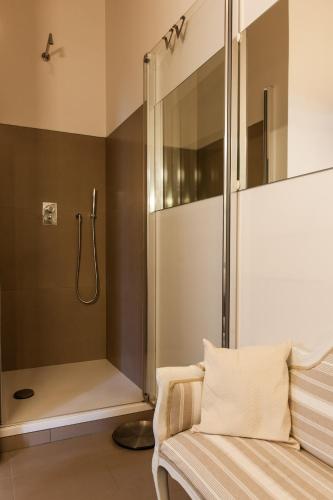 a shower stall in a bathroom with a couch and a shower at Borgo dei Salinari Apartments in Cervia