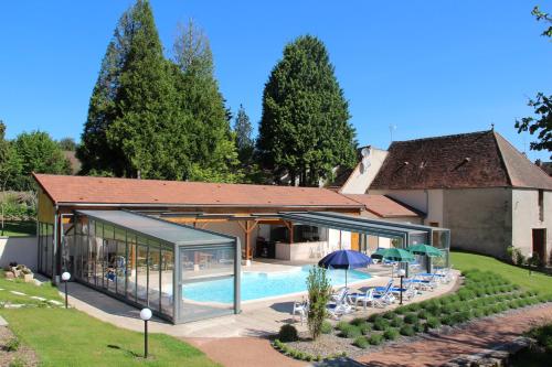 a house with a swimming pool next to a building at Logis Des Trois Maures in Couches
