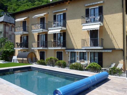 a swimming pool in front of a building at Apartments Casa Ghiggi in Brissago