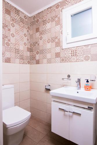 a bathroom with a toilet and a sink at Olive Garden Villas and Apartments in Chrysi Ammoudia