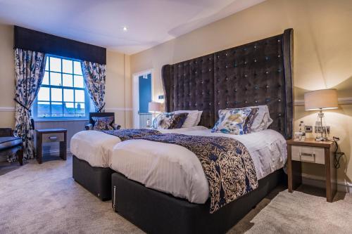 A bed or beds in a room at The Golden Fleece Hotel, Thirsk, North Yorkshire 